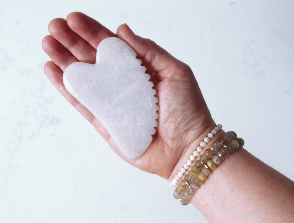 Natural stone Gua Sha tools can help create skin benefits when you learn how to use them properly. This Gua Sha moonstone tool has ridges on one edge to help grip the skin for massage.