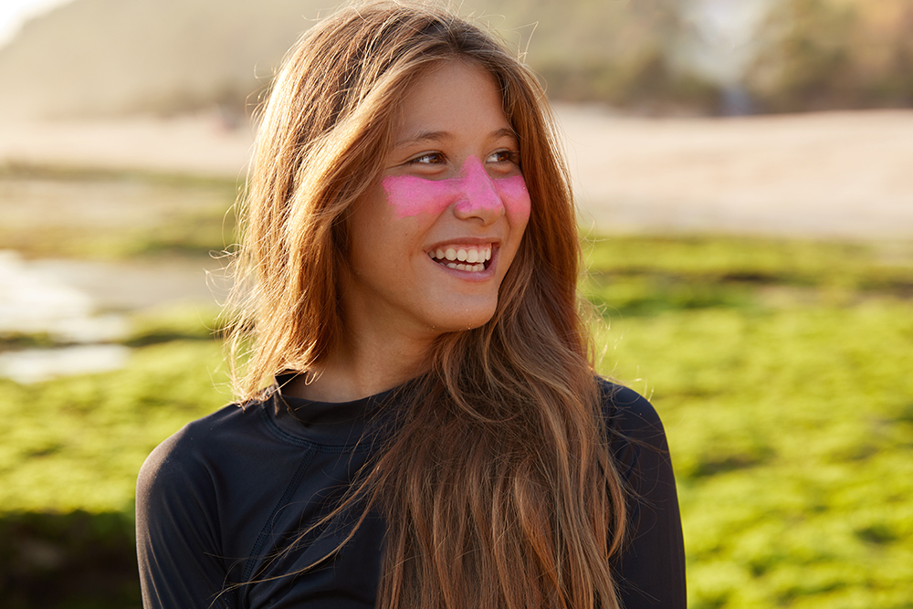 Zinc oxide surfer sunscreen on a girl with a pink nose for UV protection using a mineral UV filter